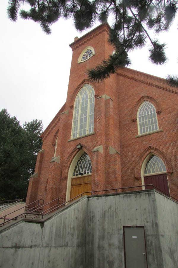 The red-brick St. Ignatius Mission church, its tall arched windows and gabled front rising above a concrete stair