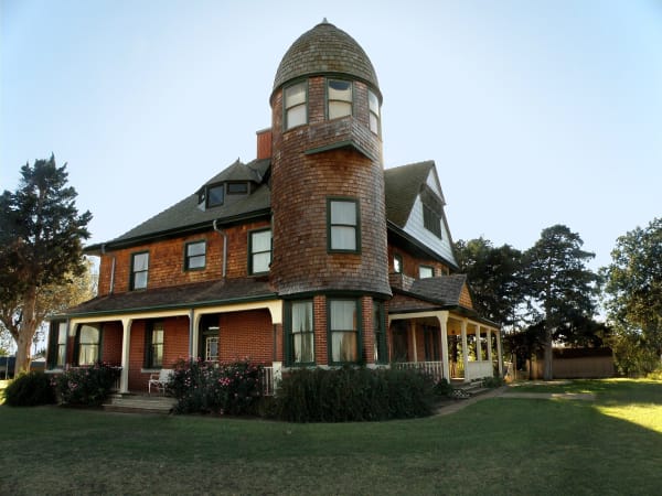 Horizon Hill, the 1892 Seay Mansion in Kingfisher, a red brick and shingle Queen Anne house with a round tower and wraparound porch.