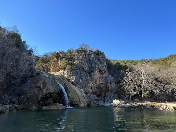 Turner Falls pouring over a rock face into the pool on Honey Creek.