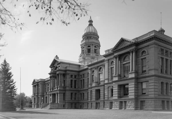 A black-and-white survey photograph of the Wyoming State Capitol in Cheyenne, its sandstone wings and domed tower seen from the southeast