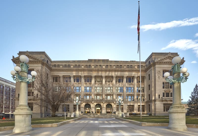 The front of the 1912 Douglas County Courthouse in Omaha, seen down its entrance walk between two lamp standards.