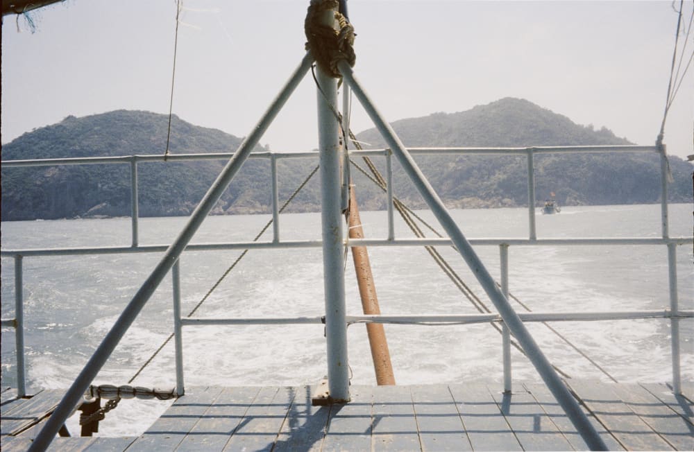 Boat railings framing islands and the sea
