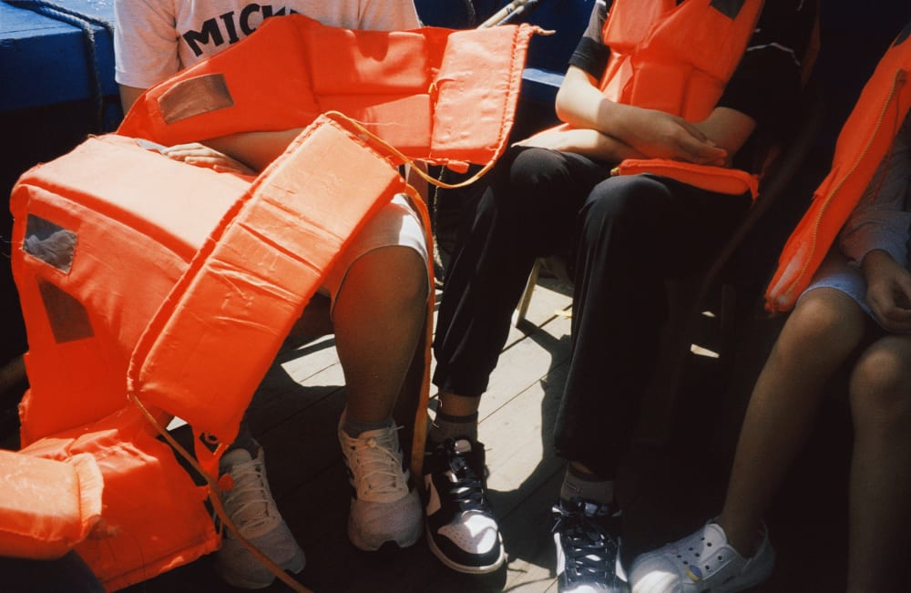 Passengers seated with orange life jackets