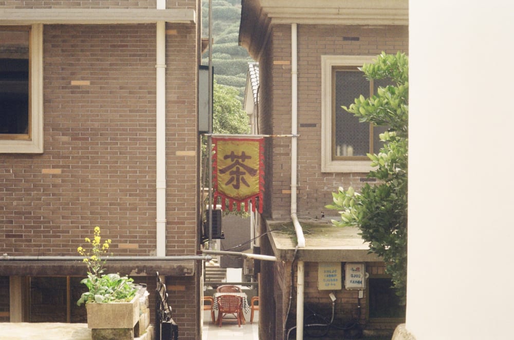 A tea banner between brick buildings