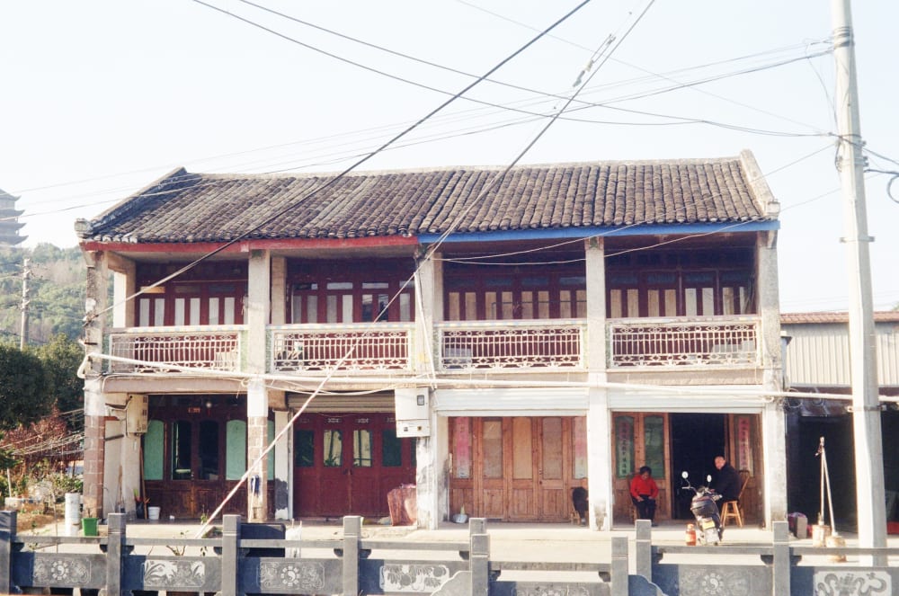 People outside a tiled-roof house