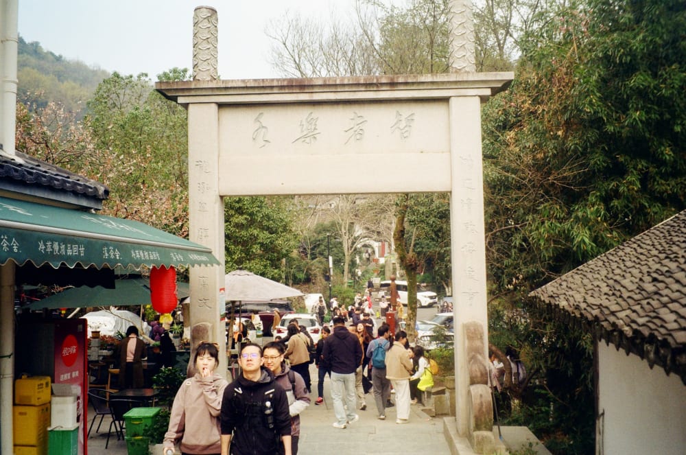 People beneath a stone gateway
