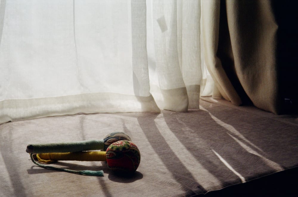 Window light falling across a table and a fabric toy