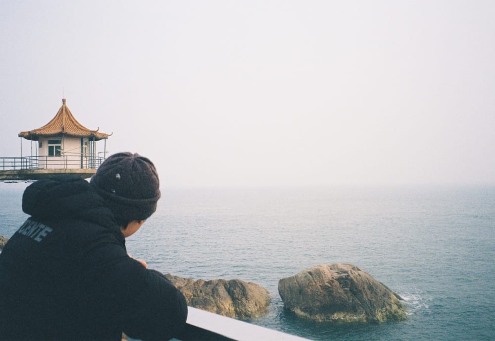 A person looking toward a seaside pavilion