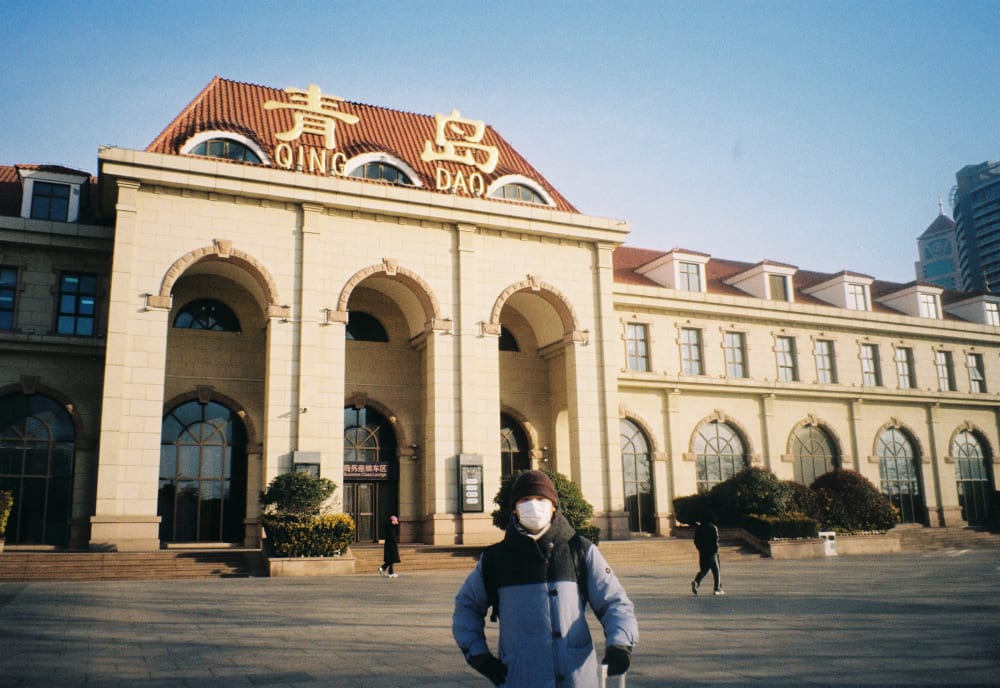 A person standing in front of Qingdao railway station