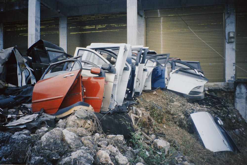 Detached car doors arranged outside closed workshops