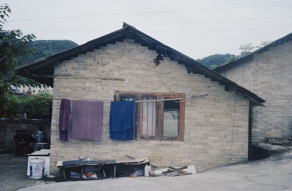 Purple and blue towels hanging on a brick house