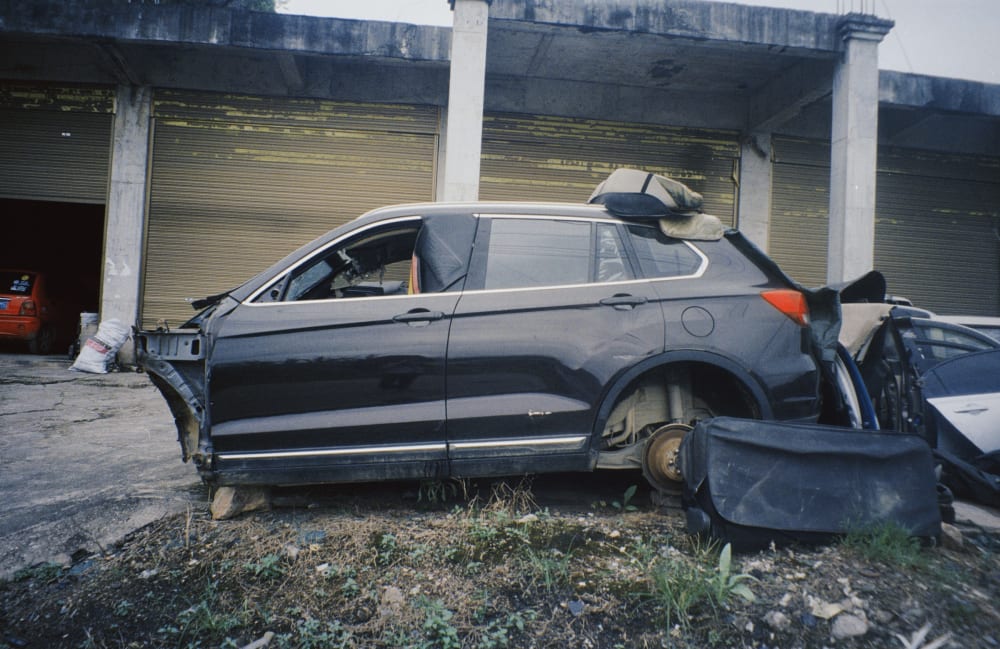 A dismantled car outside a workshop
