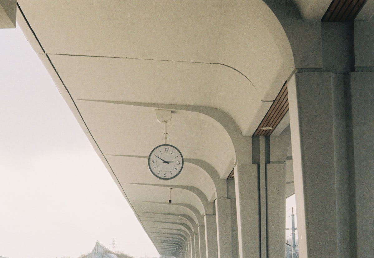 A clock beneath the arches of a railway platform