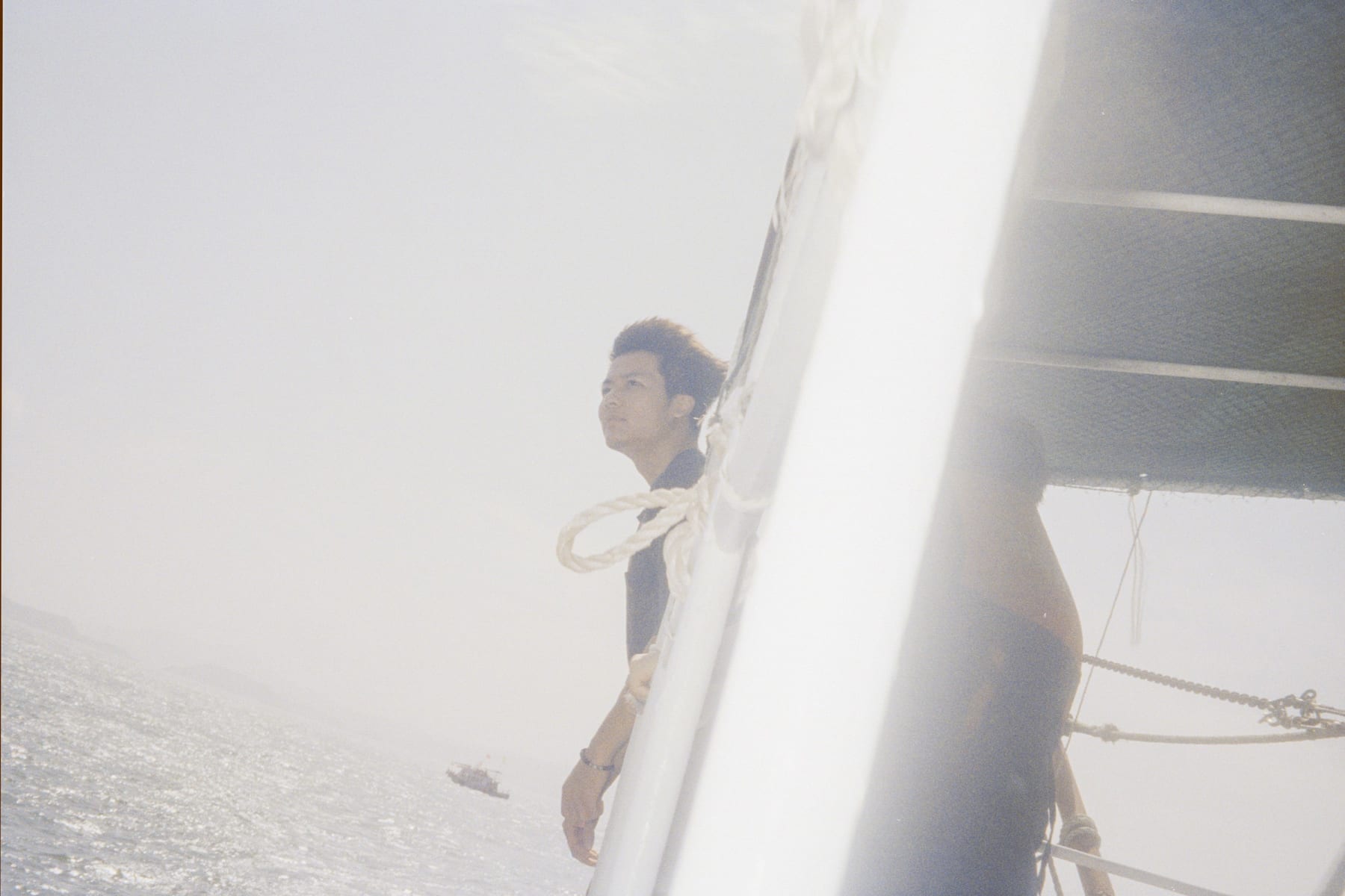 A person on a boat seen through a translucent curtain
