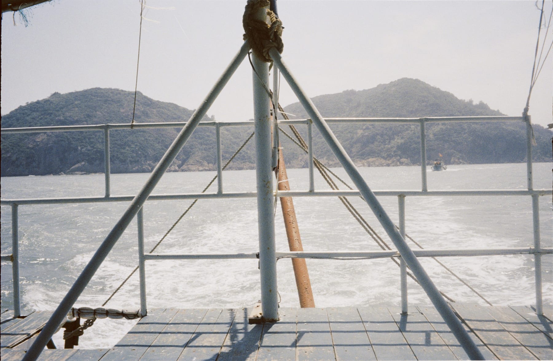 Boat railings framing islands and the sea