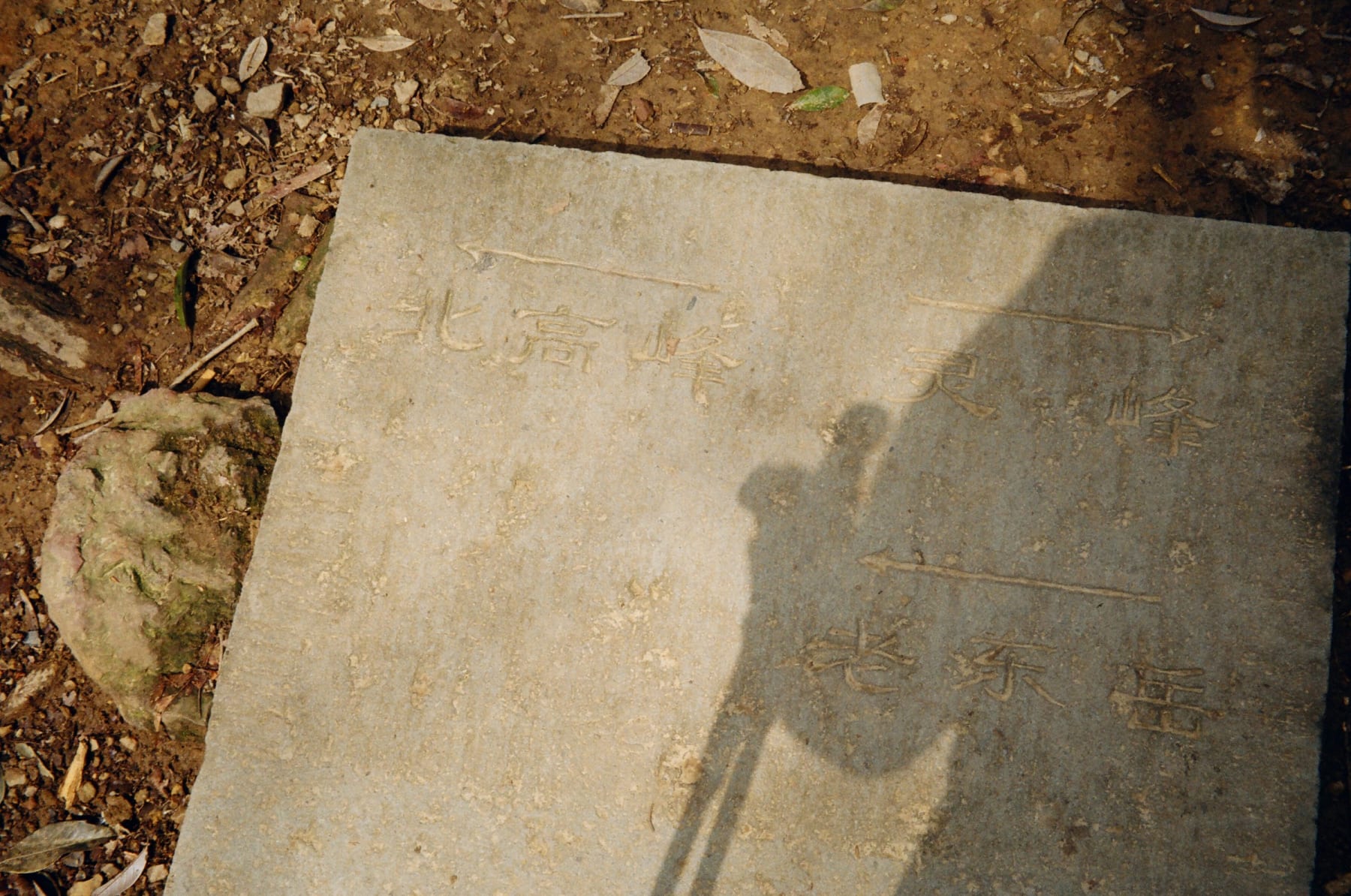 A shadow across an engraved stone slab