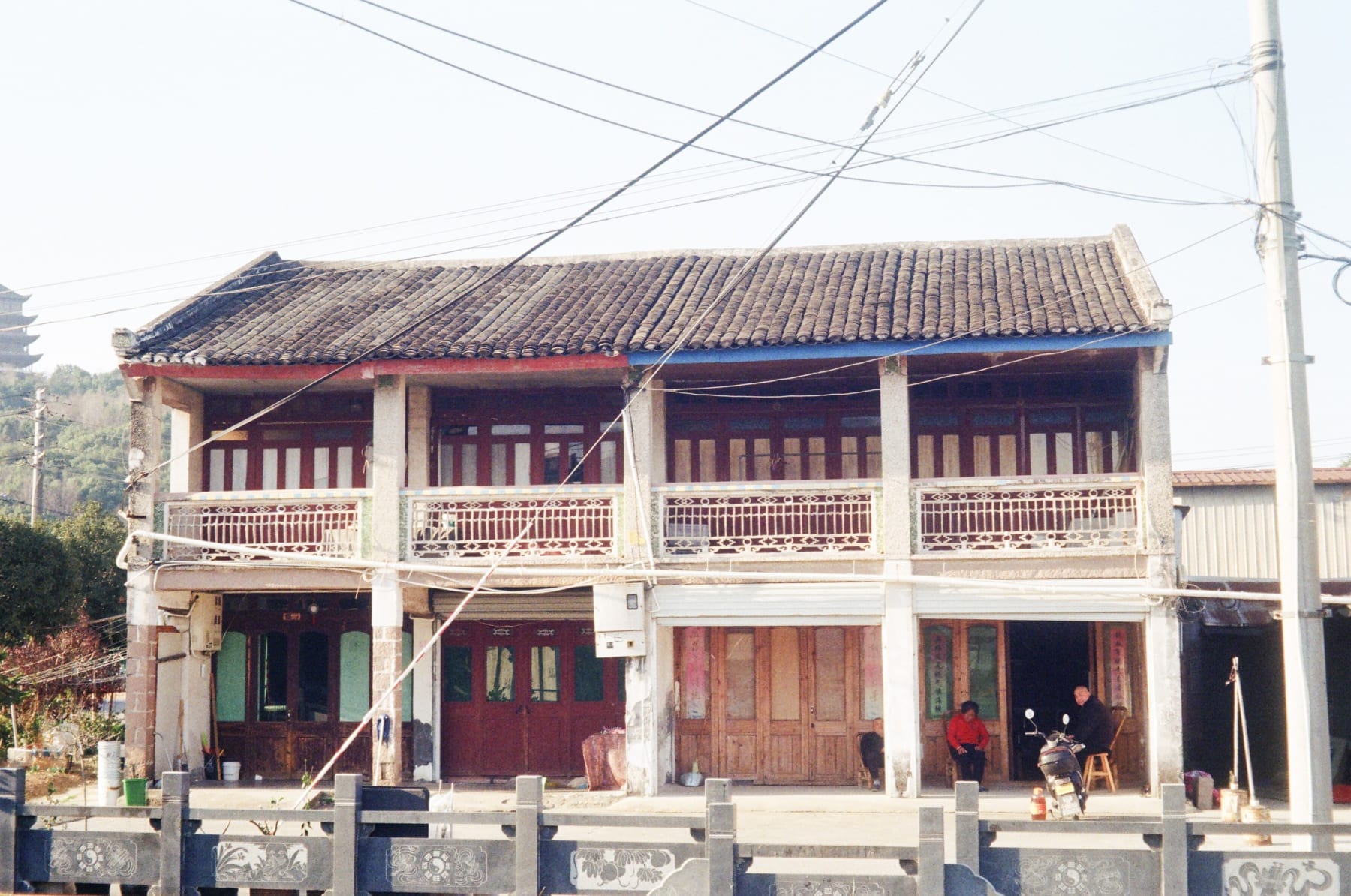 People outside a tiled-roof house