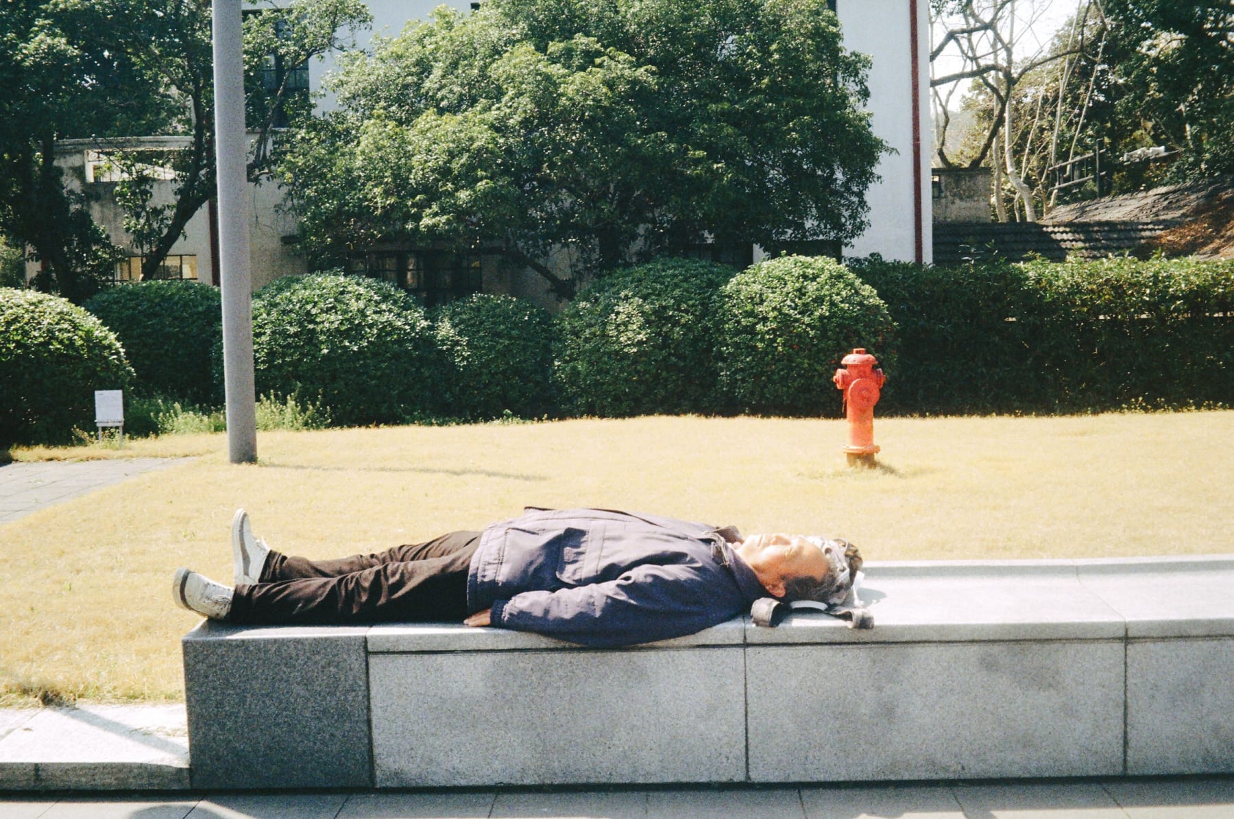 A person resting on a stone bench