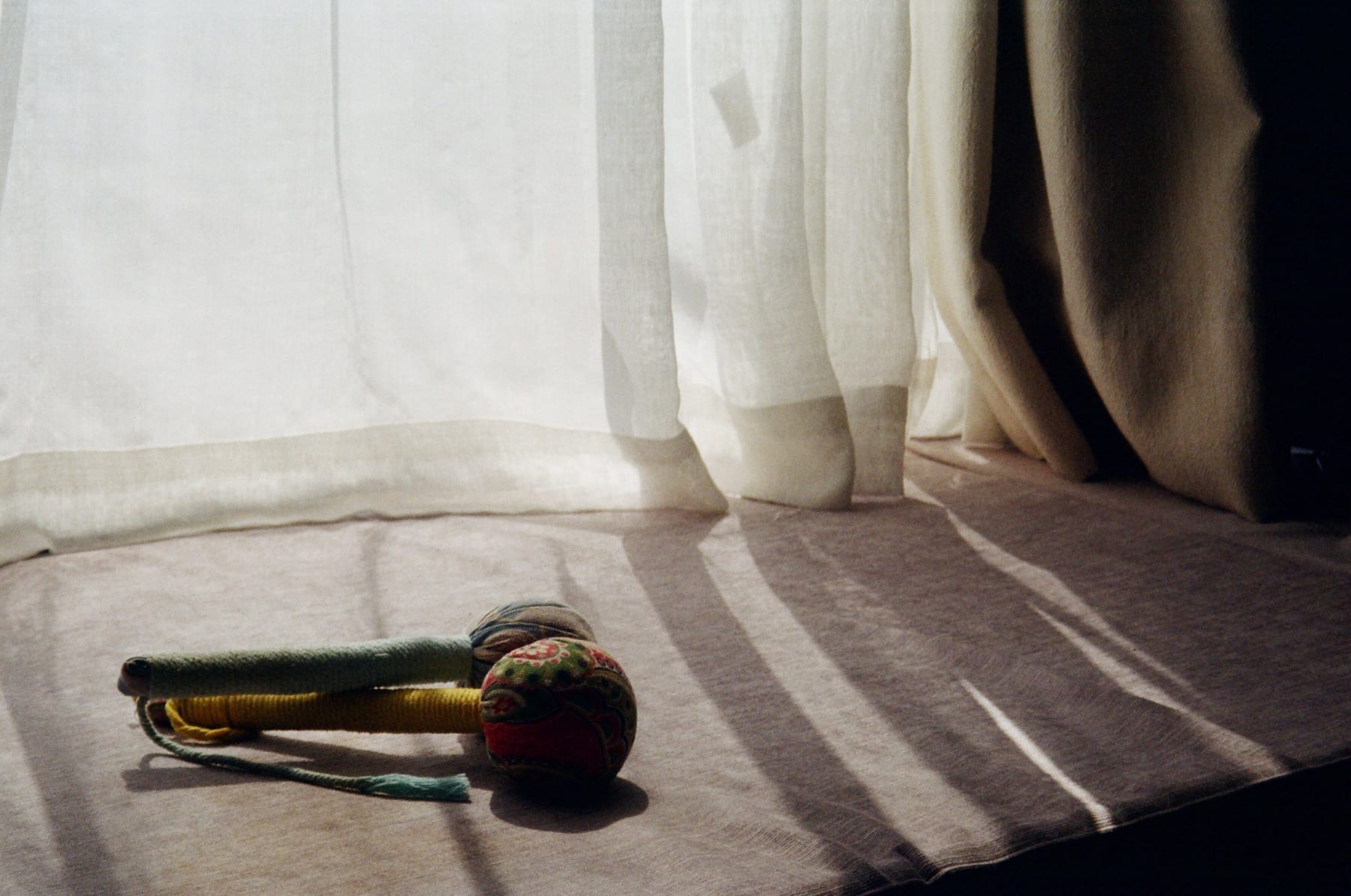Window light falling across a table and a fabric toy