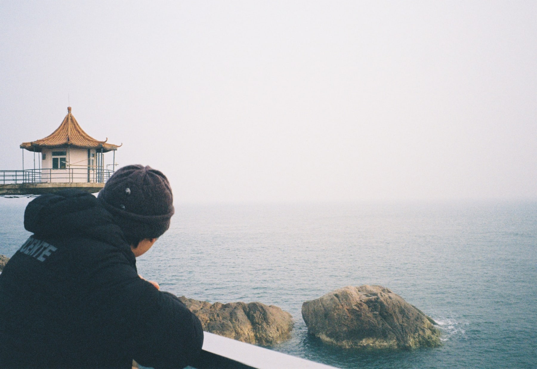 A person looking toward a seaside pavilion