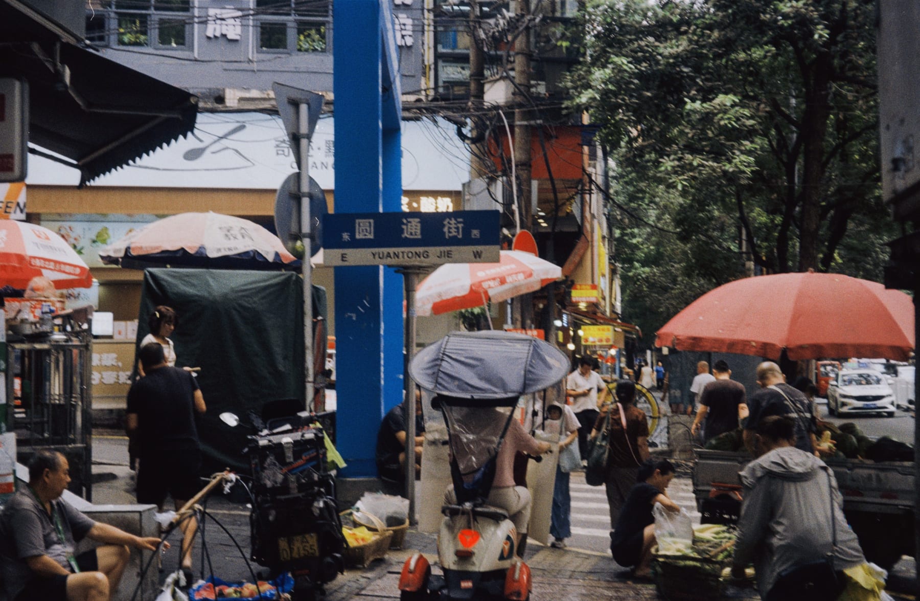 People and market umbrellas along a busy street