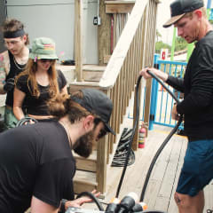 Crew running cable during load-in at an outdoor Gulf Coast venue
