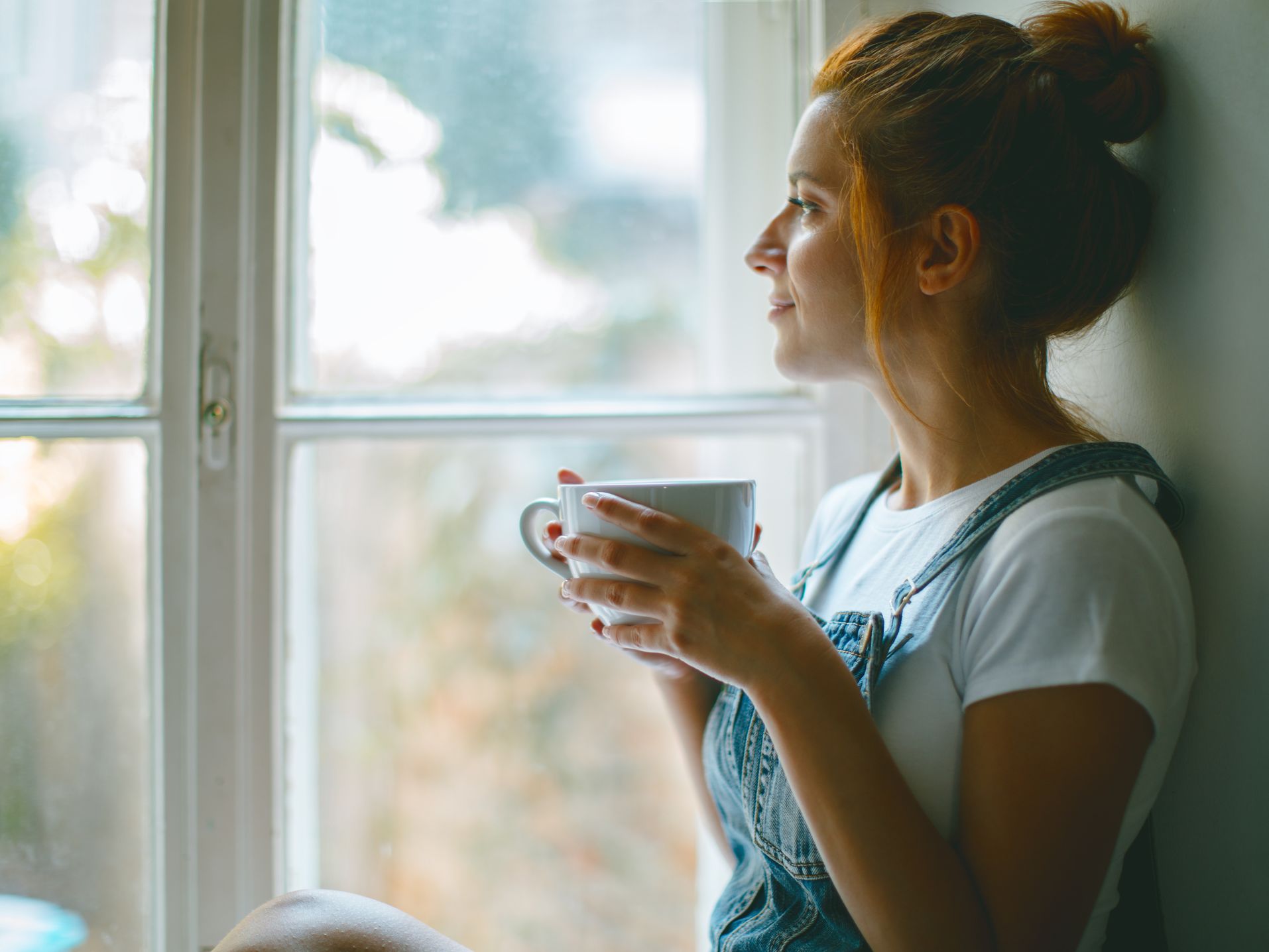 Image showing a woman sitting on a windowsill.