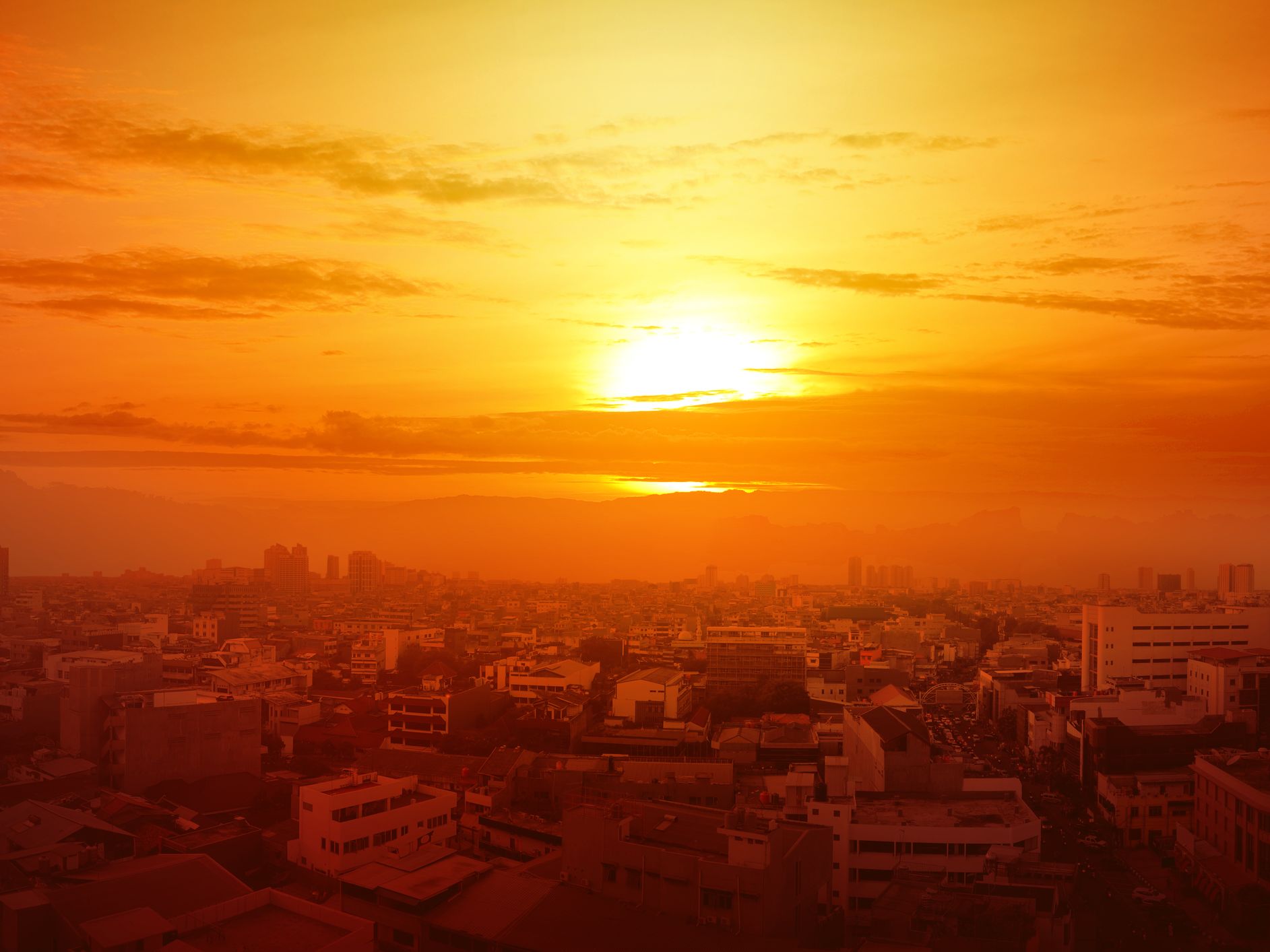 Image of a sun setting over a city.