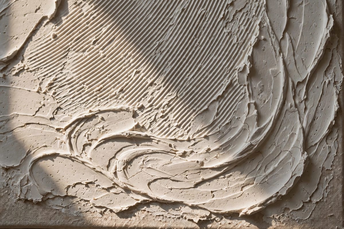 Close-up of dried textured plaster art showing comb-line details on canvas