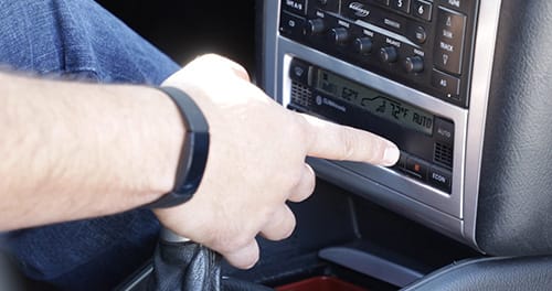 Make sure your heater is working before the temperatures drop Person changing heat settings in car