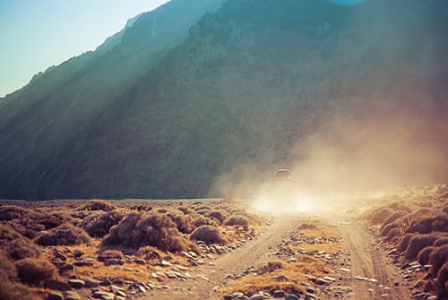 Car on dusty desert road