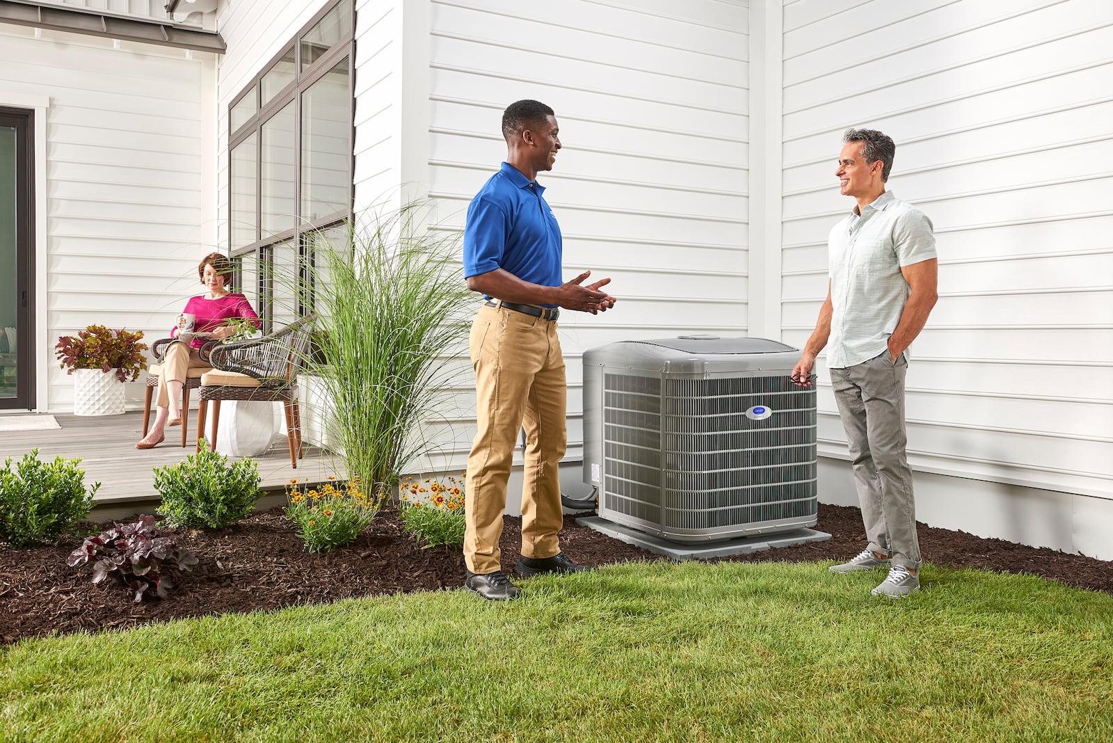 Bryant technician talking with homeowner while checking air filter and furnace