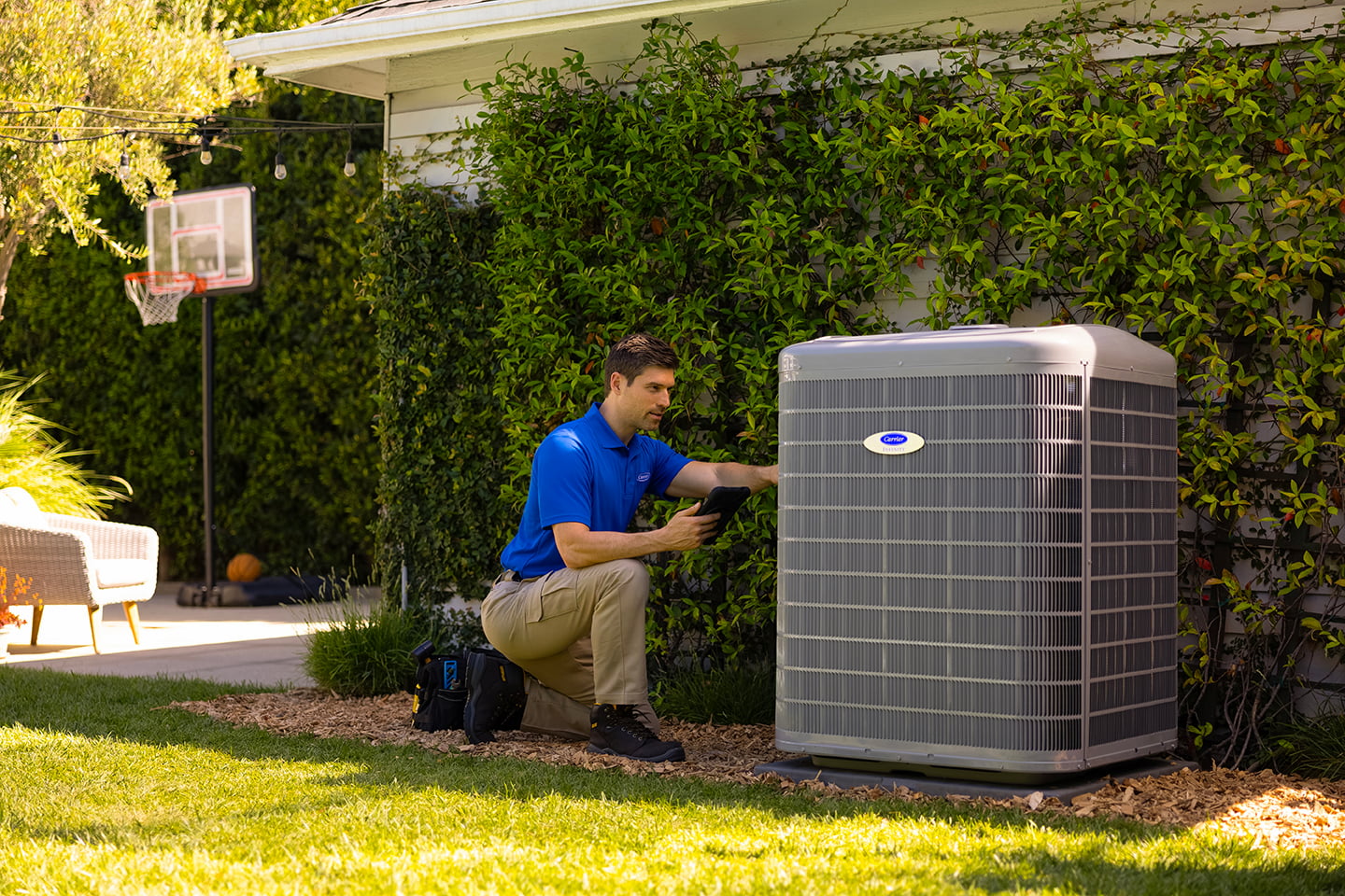 Bryant technician talking with homeowner while checking air filter and furnace