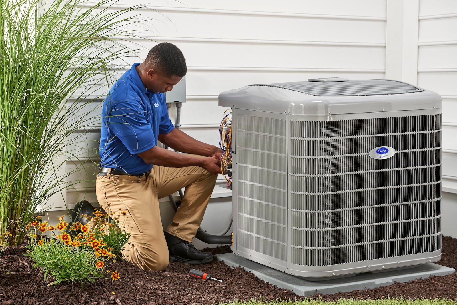 Bryant technician talking with homeowner while checking air filter and furnace