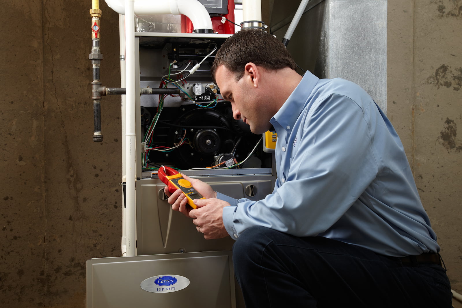 Bryant technician talking with homeowner while checking air filter and furnace