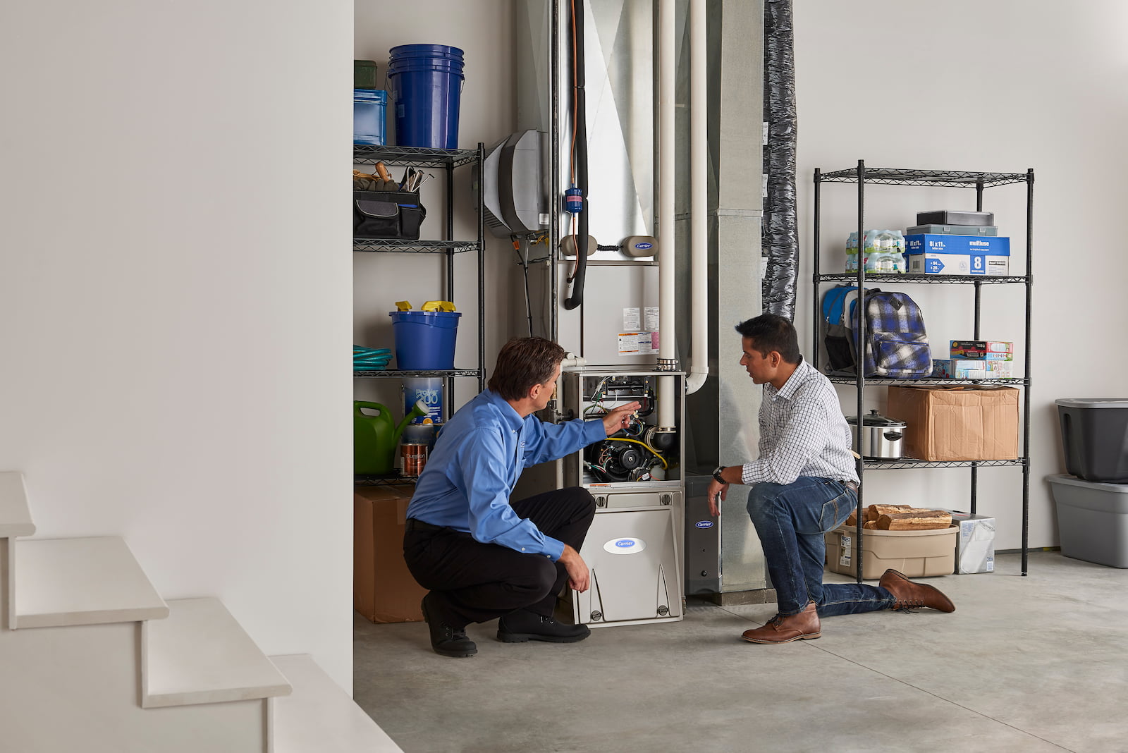Bryant technician talking with homeowner while checking air filter and furnace