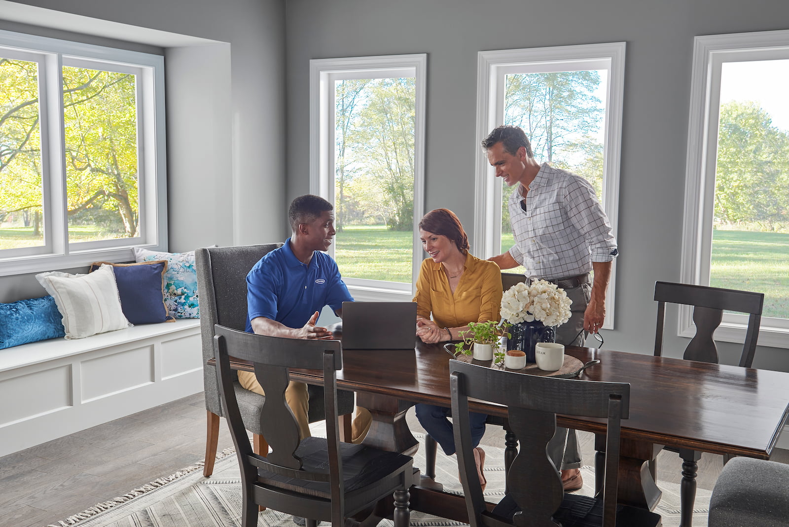 Bryant technician talking with homeowner while checking air filter and furnace