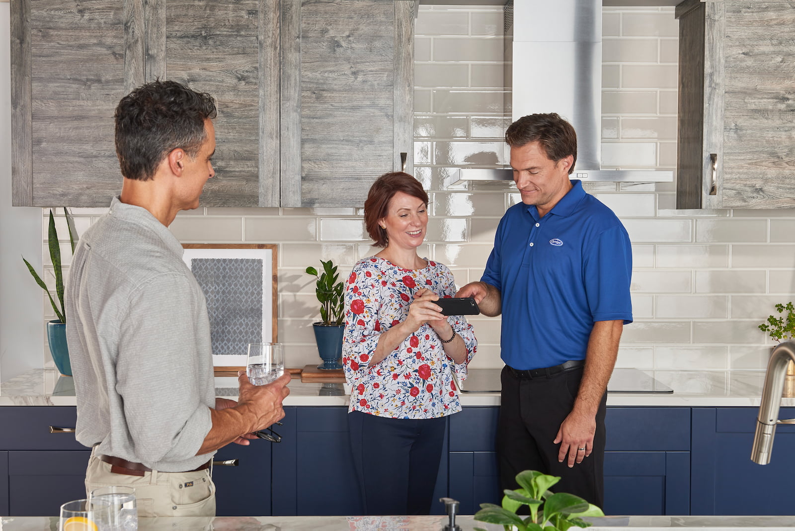 Bryant technician talking with homeowner while checking air filter and furnace
