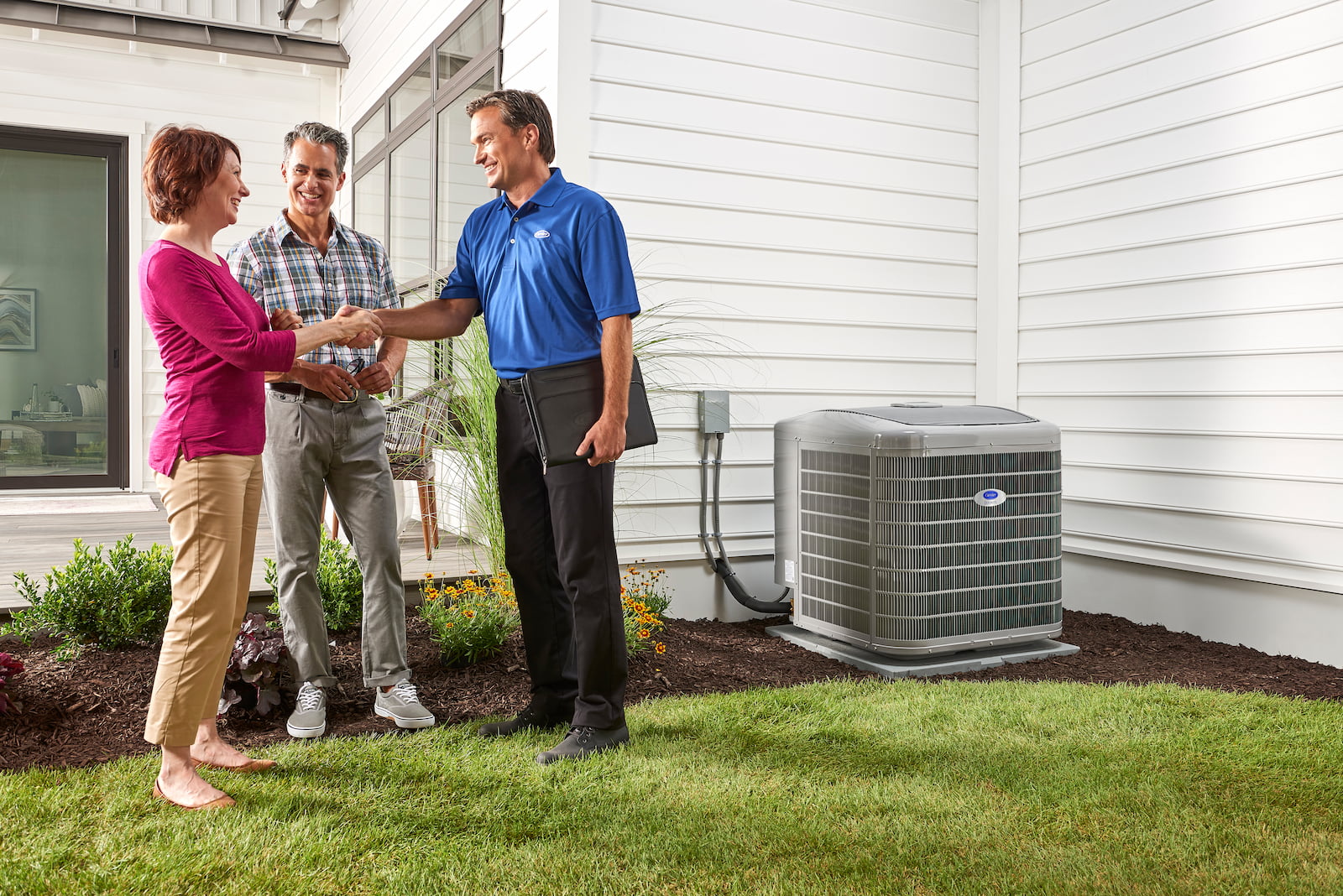 Bryant technician talking with homeowner while checking air filter and furnace