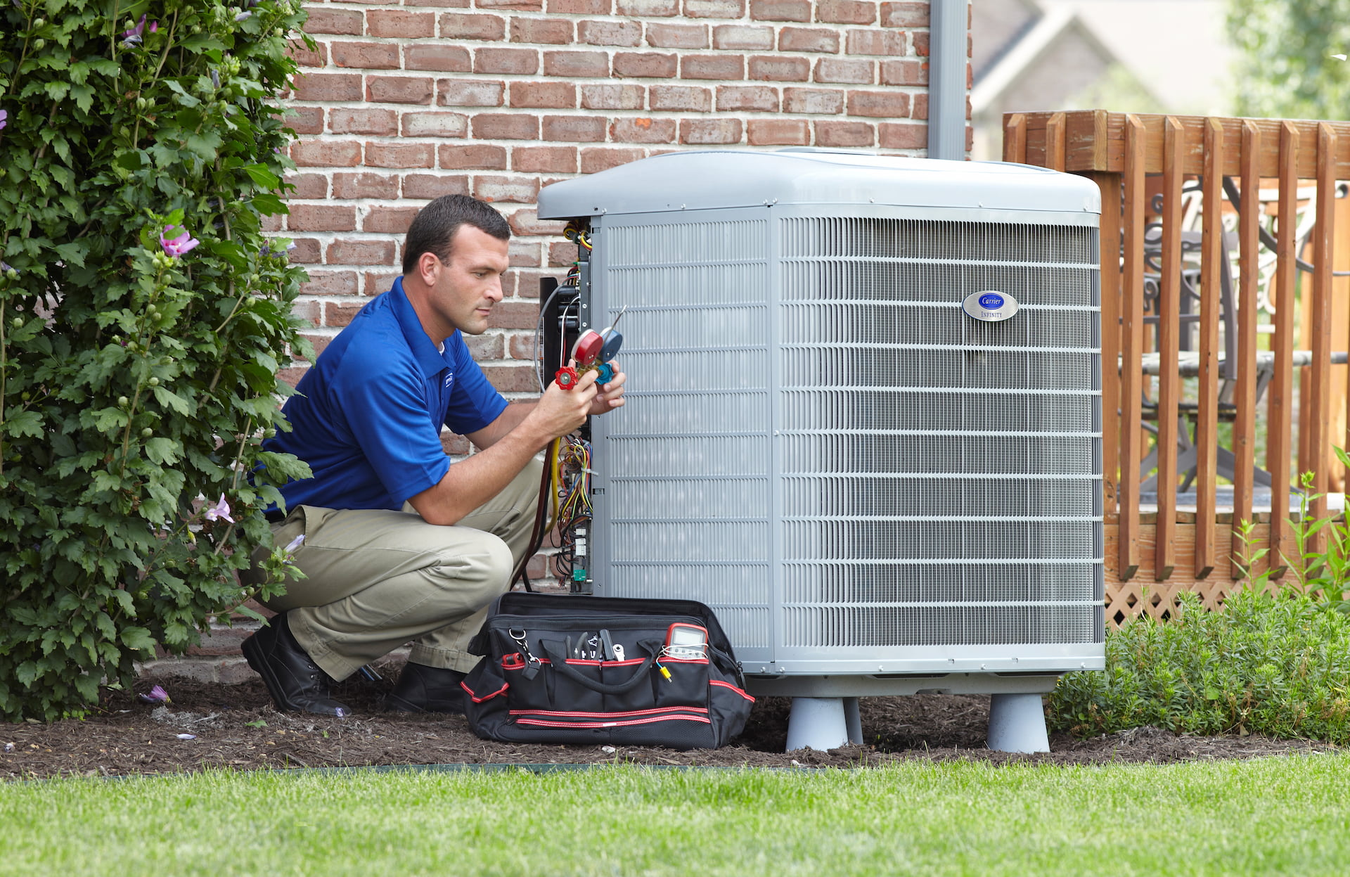 Bryant technician talking with homeowner while checking air filter and furnace