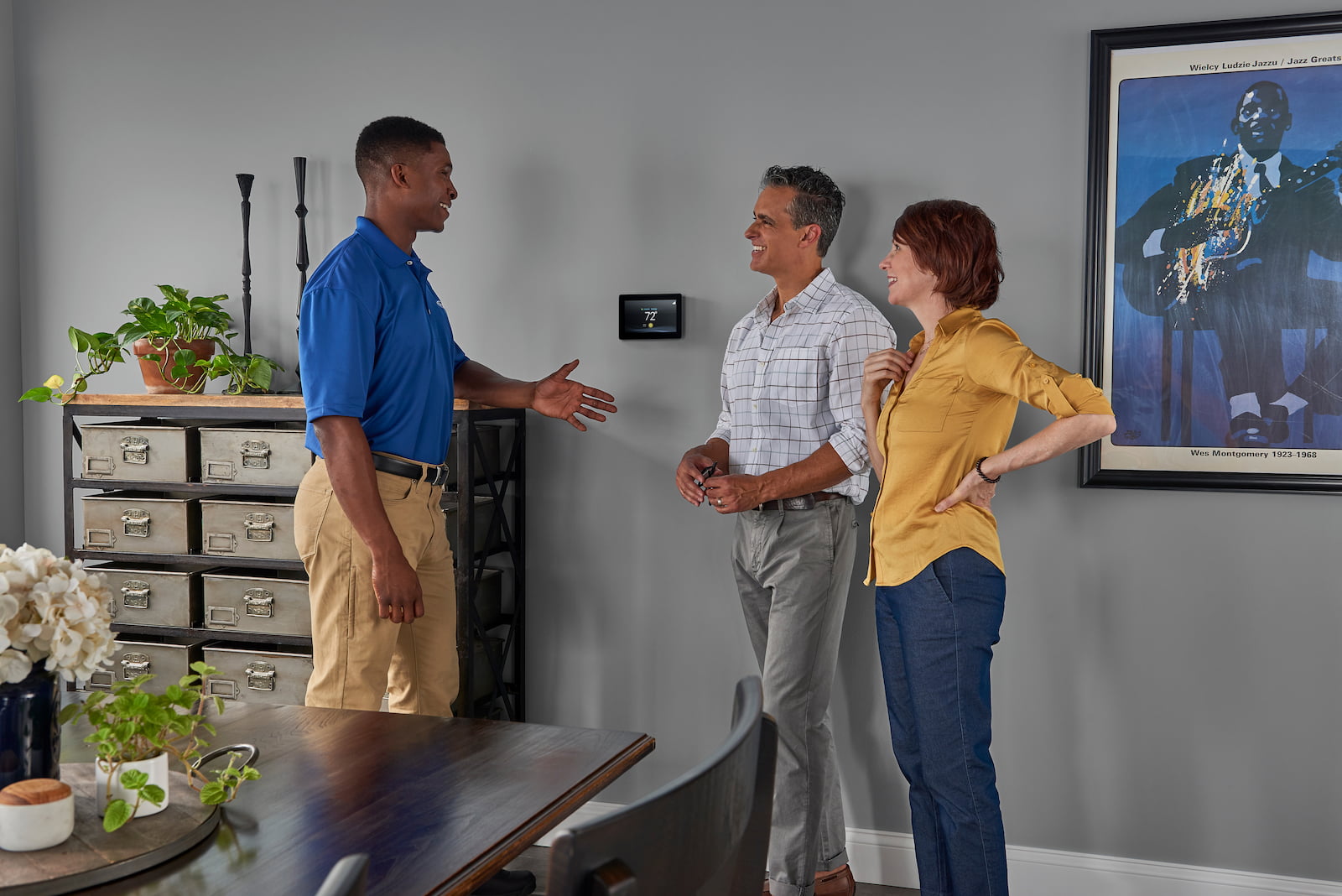 Bryant technician talking with homeowner while checking air filter and furnace