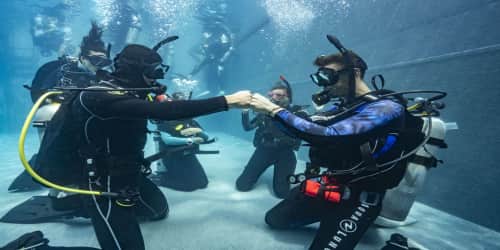 Koh Tao Divers instructor guiding a scuba diving session in a clear pool with multiple students