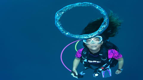 Koh Tao Divers scuba diver blowing a bubble ring underwater in perfect control