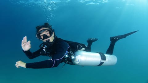 Koh tao divers female sidemount diver giving OK sign underwater