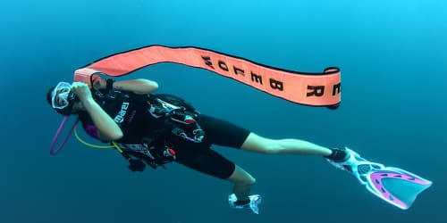 Koh Tao Divers diver deploying surface marker buoy (SMB) during ascent as part of rescue training.
