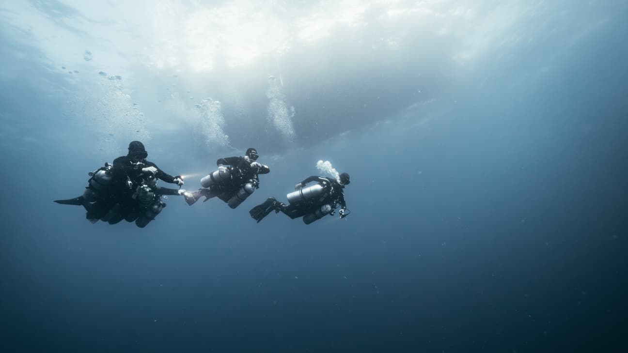 Koh tao divers conducting a deep technical dive in open water with multiple tanks.