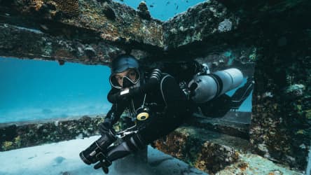 Koh Tao Divers diver navigating tight structure of artificial reef underwater
