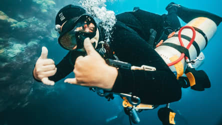 Koh Tao Divers technical diver giving hand signal underwater with twin tanks and gear