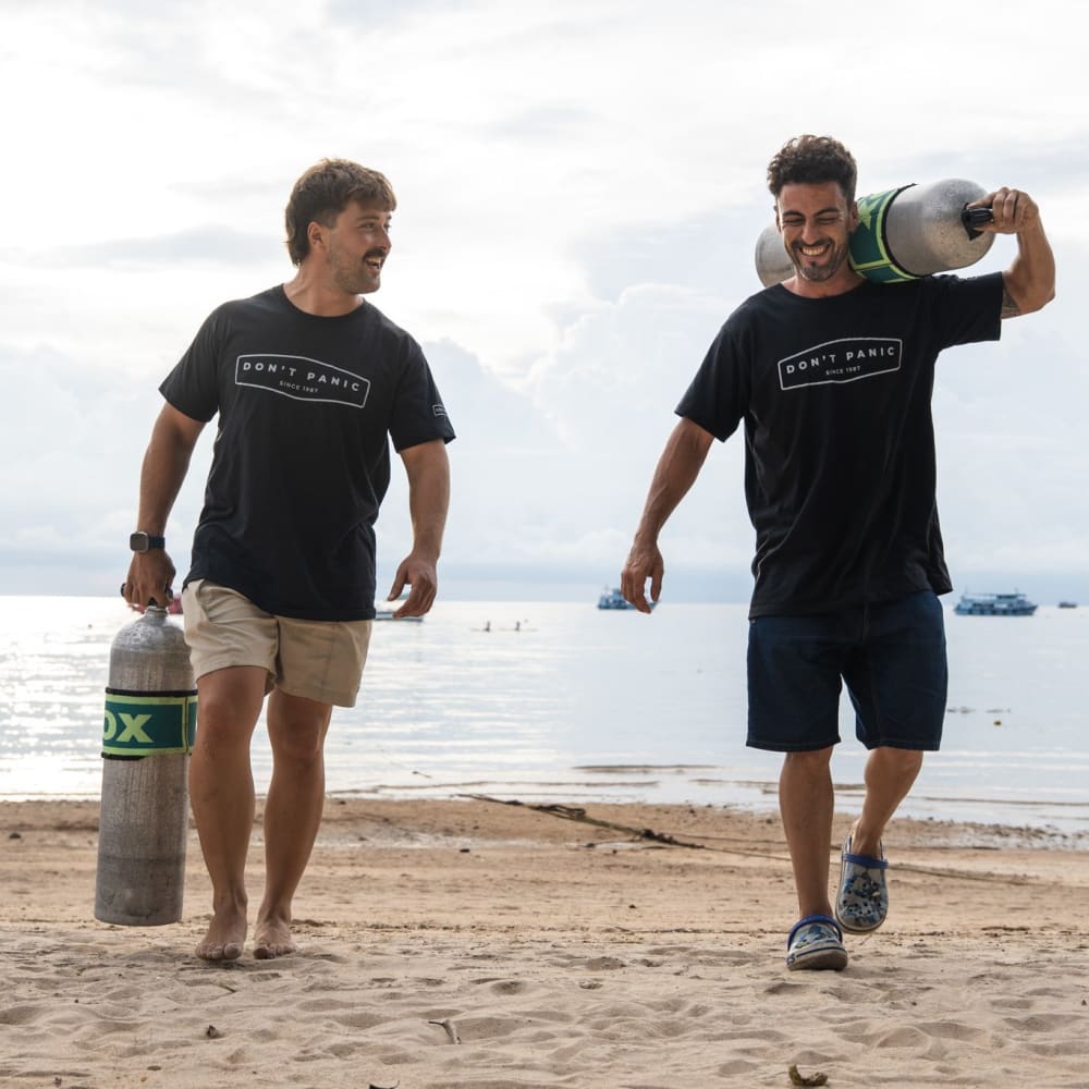 Koh Tao Divers students carrying labeled Nitrox tanks on the beach after training dive.