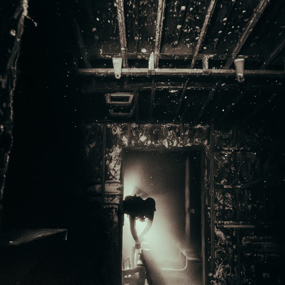 Koh tao divers technical diver exploring inside a dark shipwreck with a dive torch